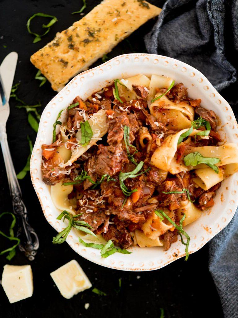 Ragù di Manzo a Lunga Cottura 2 ragù di manzo su pasta guarnito con basilico e parmigiano