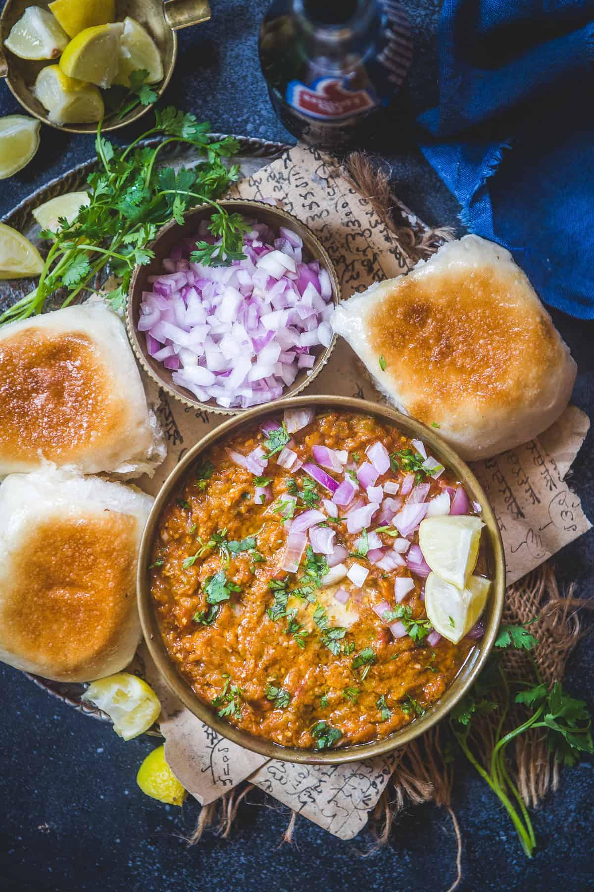 Una ciotola di Pav Bhaji appena preparato, guarnito con una generosa noce di burro e coriandolo fresco.