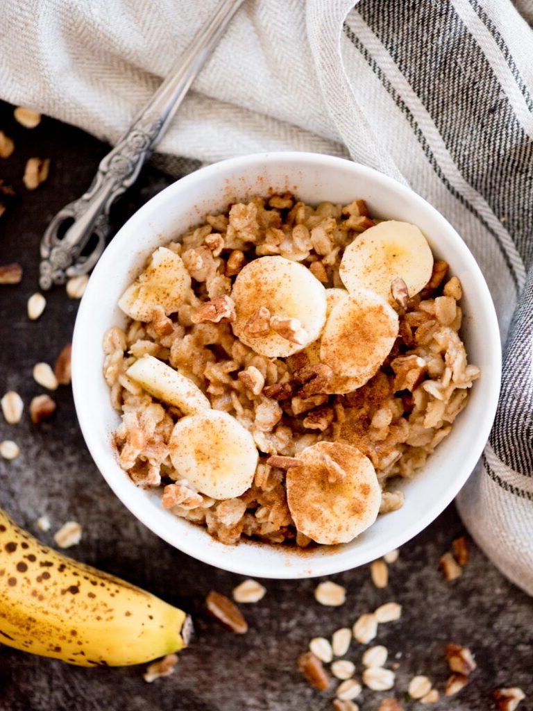 Ricetta di Porridge al Banana Bread 2 banana oatmeal in a bowl topped with nuts and cinnamon