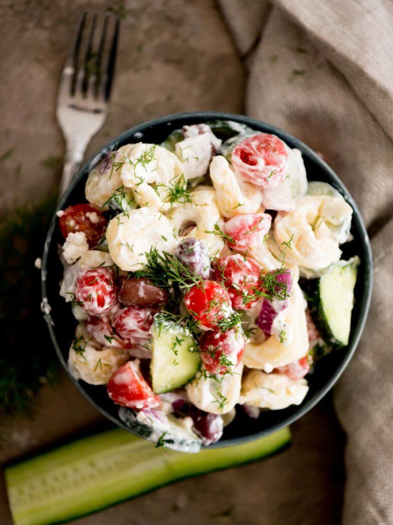 Insalata Fredda di Tortellini alla Greca 2 Insalata di pasta greca in una ciotola guarnita con aneto fresco