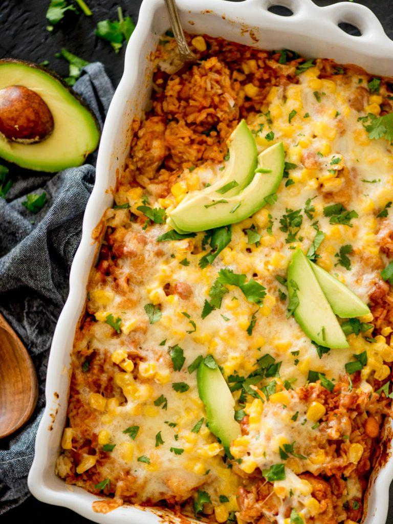 casseruola di riso messicana con pollo, guarnita con coriandolo e avocado