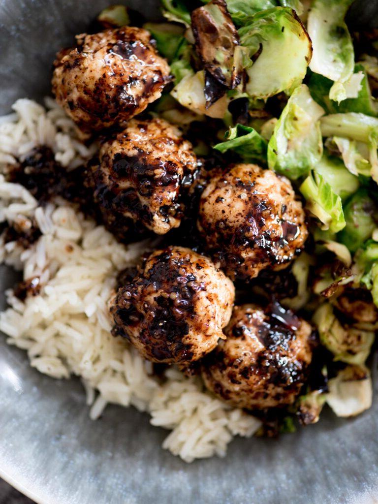 Polpette di pollo caramellate 2 Polpette di pollo agrodolci in una ciotola con riso e cavoletti di Bruxelles