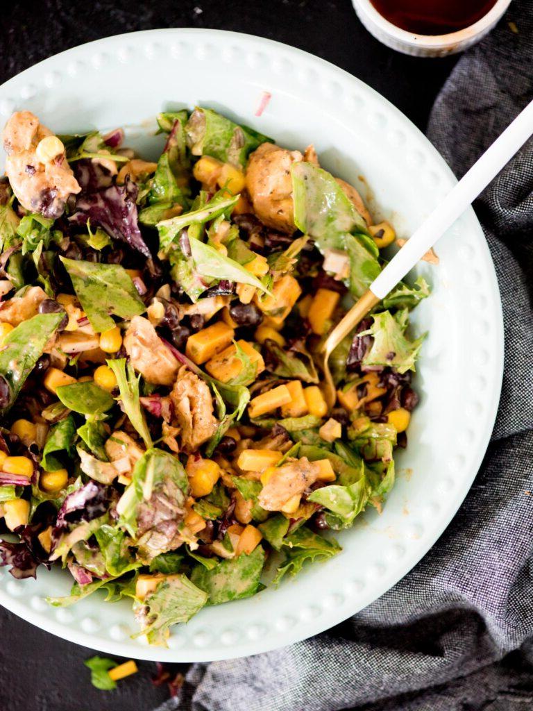 Insalata Mason Jar con pollo BBQ versata in una ciotola blu