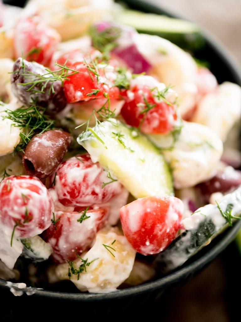 Insalata Fredda di Tortellini alla Greca 11 insalata di pasta greca in una ciotola guarnita con aneto fresco
