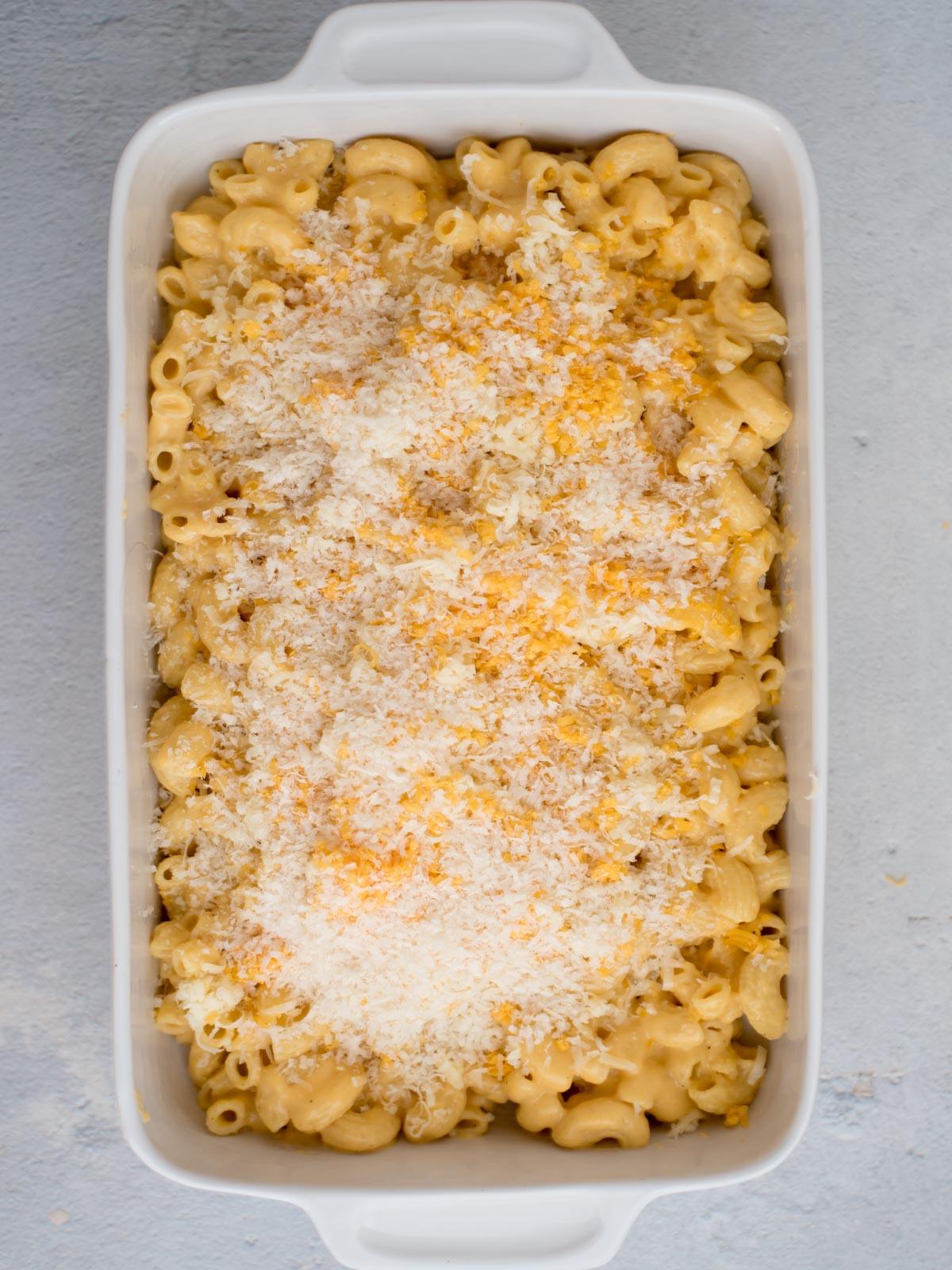 **I Migliori Maccheroni al Forno Super Formaggiosi** 11 Mac and Cheese in una teglia con formaggio grattugiato cosparso sopra, pronto per il forno.