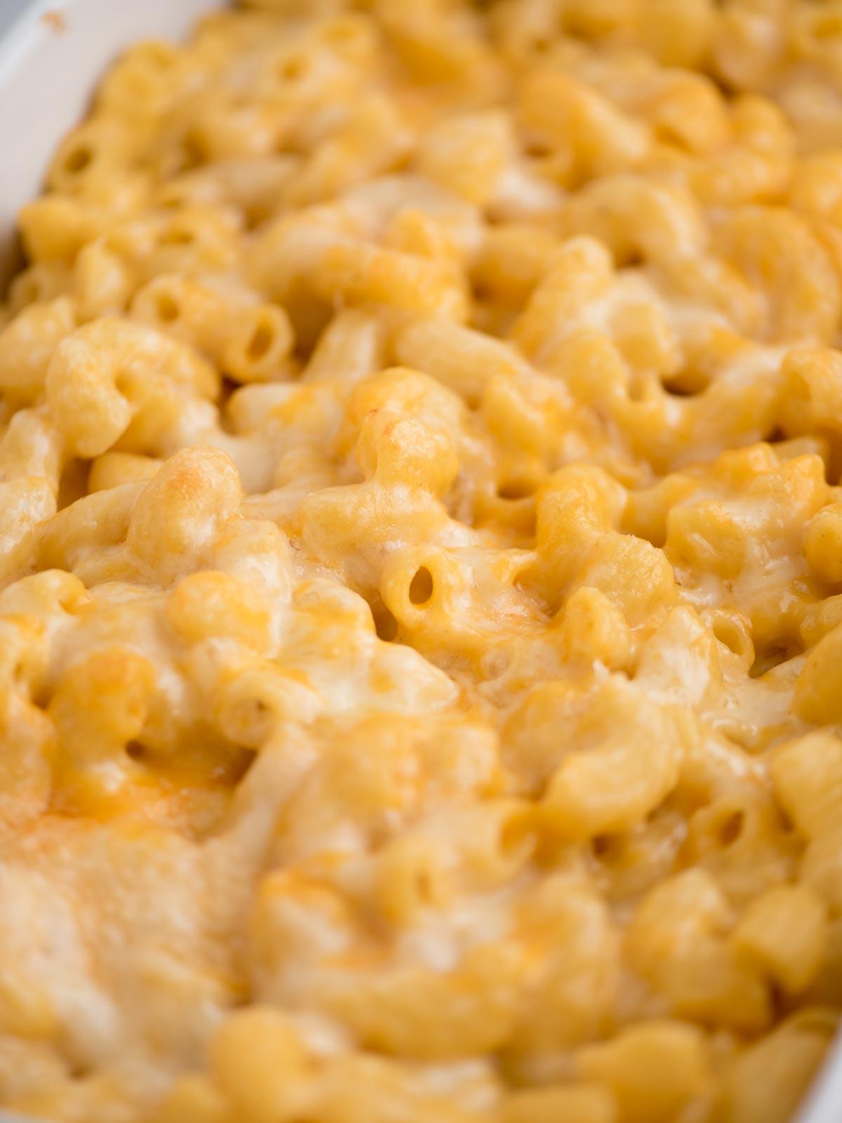 **I Migliori Maccheroni al Forno Super Formaggiosi** 12 Primo piano di una porzione di Mac and Cheese al forno, con il formaggio fuso e bollente visibile.