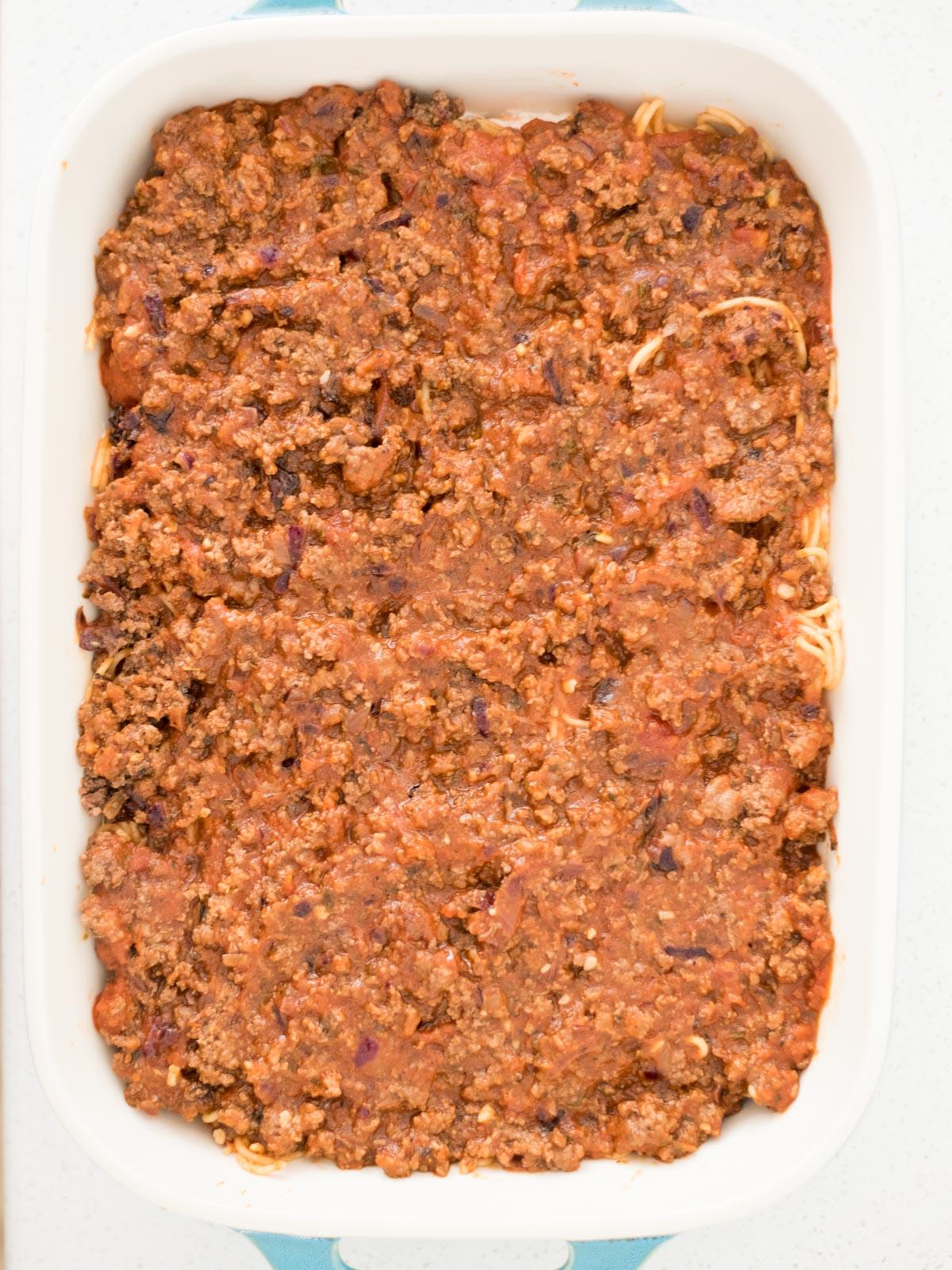 La Migliore Ricetta di Spaghetti al Forno (Facile) 12 Ragù di carne versato sopra lo strato di spaghetti, per un sapore ricco e avvolgente