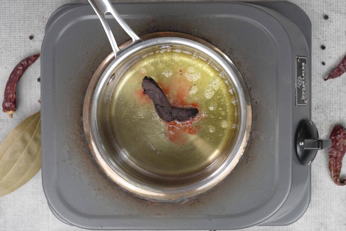 Rogan Josh di Montone 12 Ratan jot aggiunto al ghee caldo per il temperaggio.