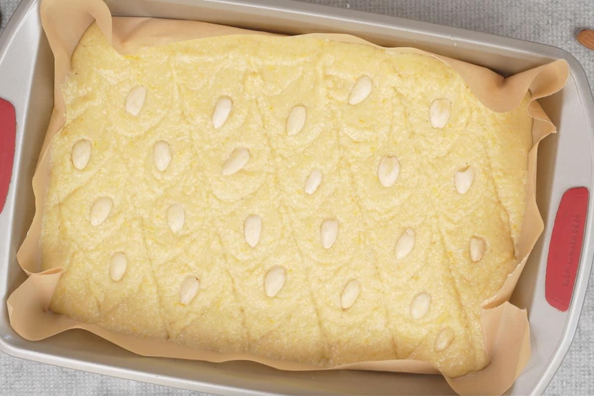 Basbousa (Torta Medio-Orientale di Semolino e Cocco) 14 Mandorle sbiancate dimezzate disposte sulla torta.