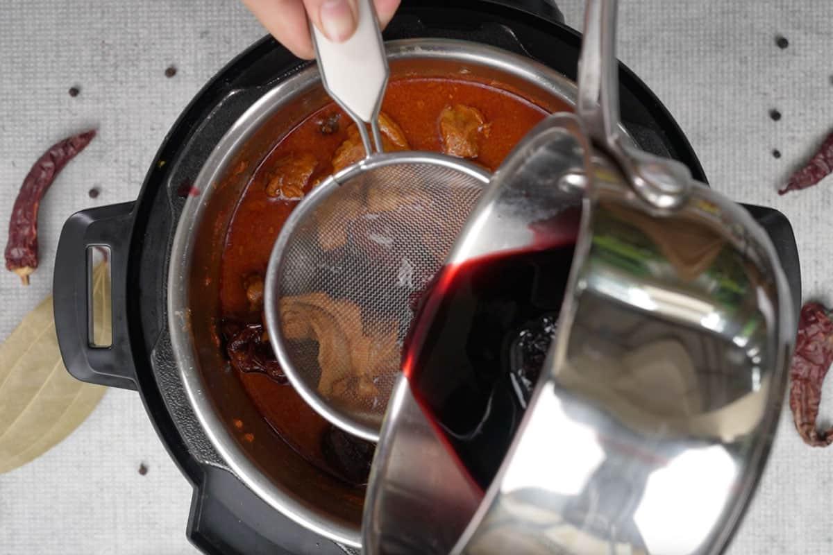 Rogan Josh di Montone 14 Versare il ghee colorato sul curry.