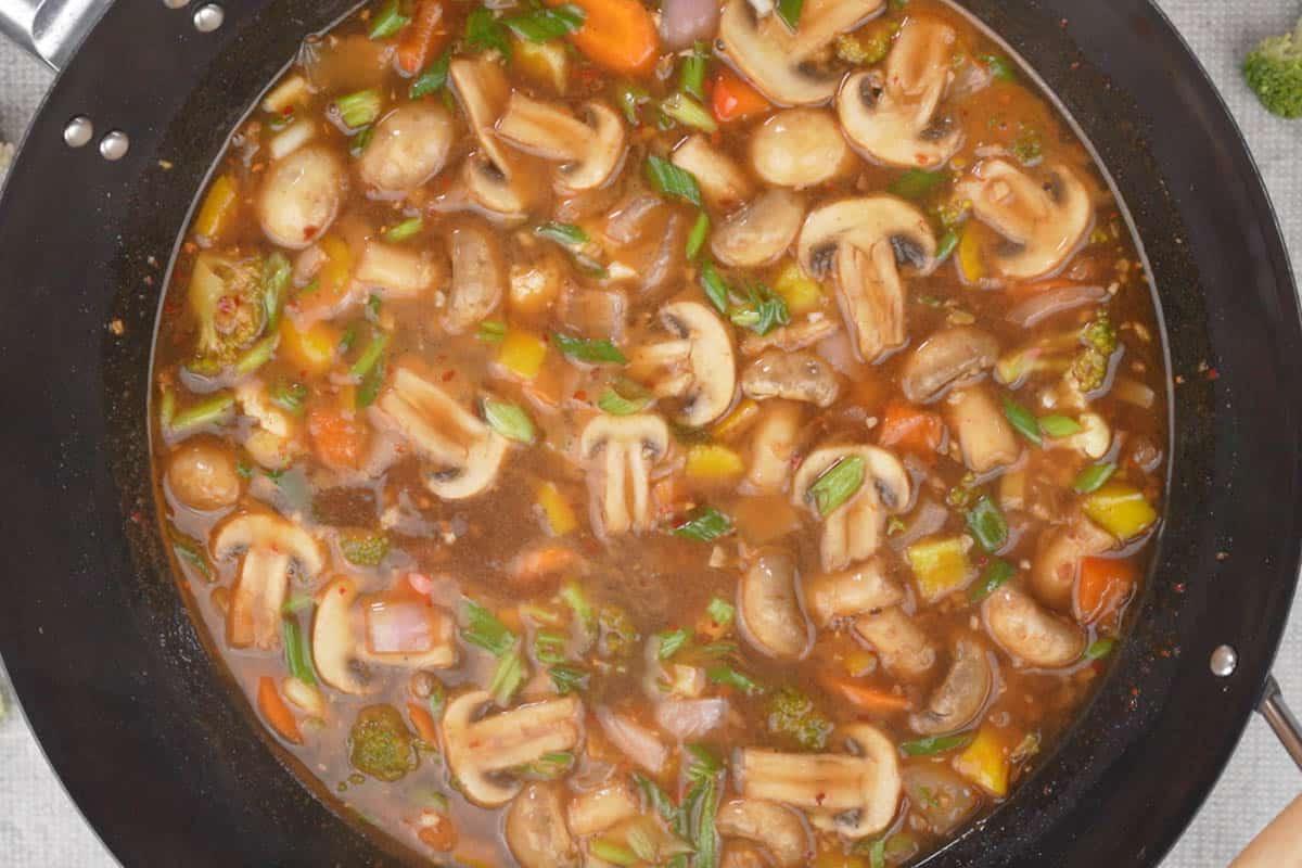 Verdure pronte in salsa piccante all'aglio guarnite con cipollotti verdi.