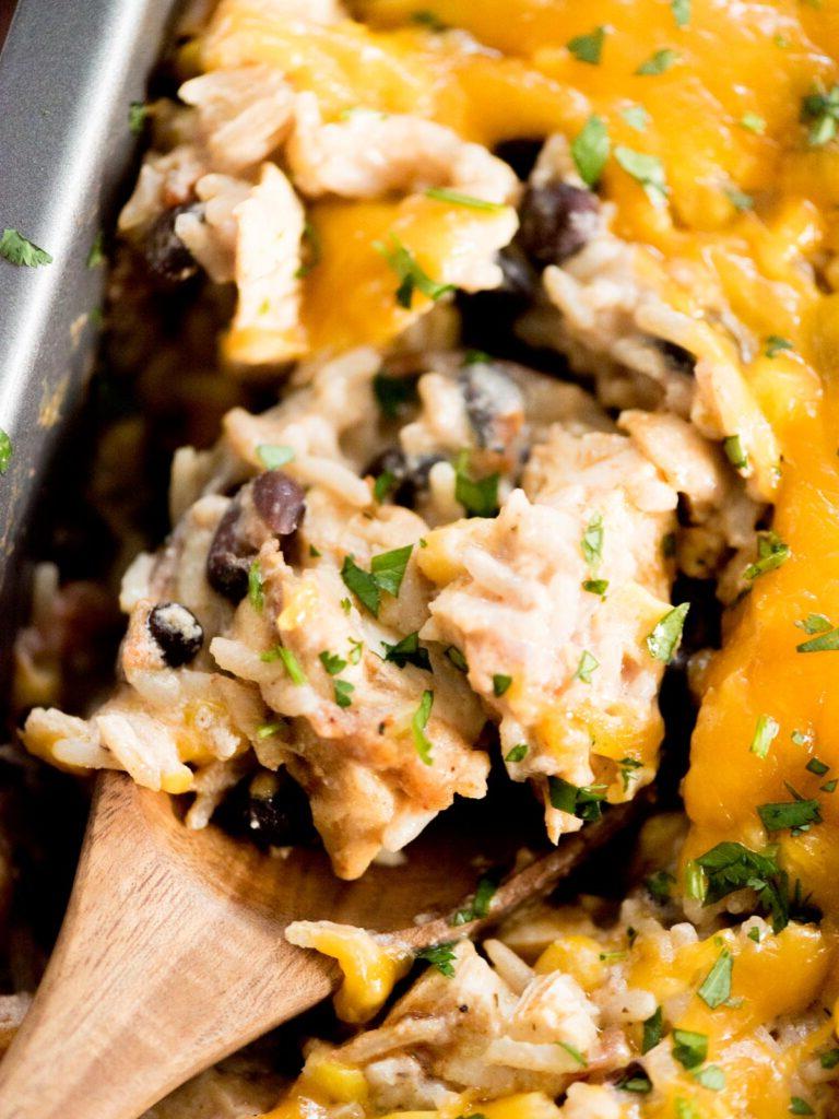 Sformato di Pollo Tex-Mex, Fagioli Neri e Riso 15 Primo piano di una porzione di teglia di pollo e riso Tex-Mex su un piatto bianco, mostrando la consistenza e i vari ingredienti.
