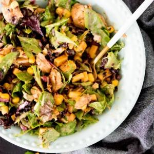 Insalata Mason Jar con pollo BBQ versata in una ciotola blu