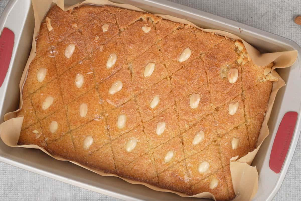 Basbousa (Torta Medio-Orientale di Semolino e Cocco) 17 Sciroppo di zucchero versato sulla Basbousa pronta.