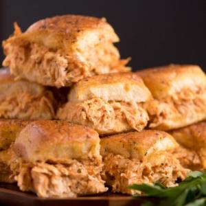 Mini-panini Hawaiani al Pollo Buffalo 17 Un mucchio di sliders di pollo Buffalo su un piatto.
