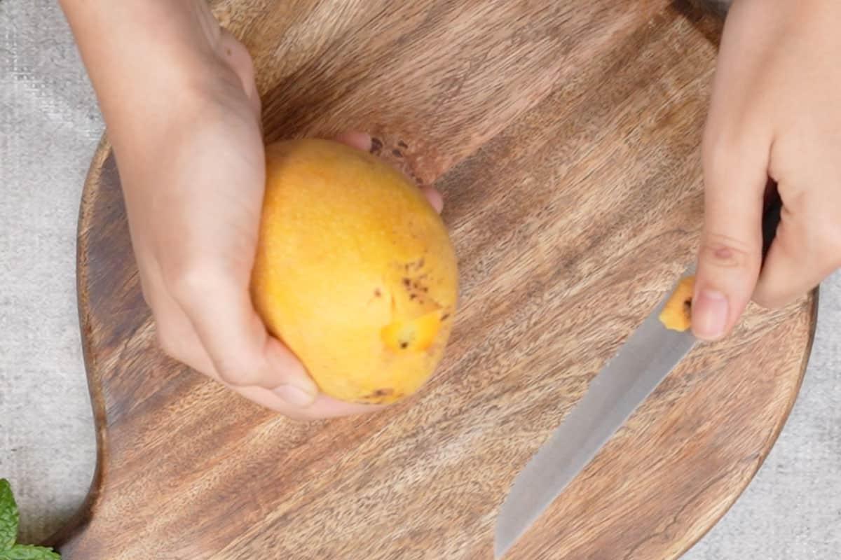 Aamras 3 Punta nera del mango rimossa con un coltello per la preparazione dell'Aamras.