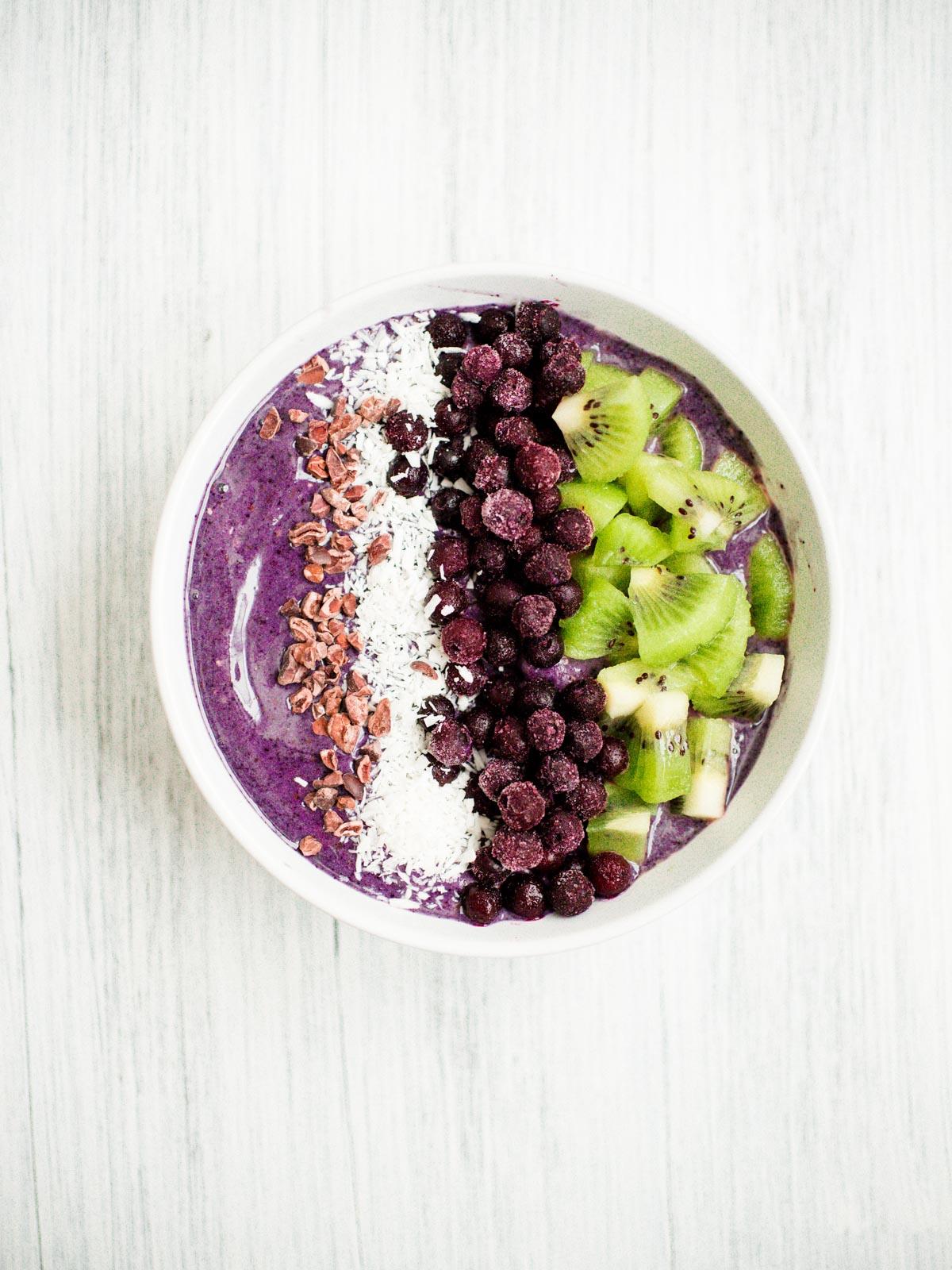 Smoothie Bowl Mirtillo e Banana 3 Smoothie bowl ai mirtilli e banane in una ciotola bianca con guarnizioni