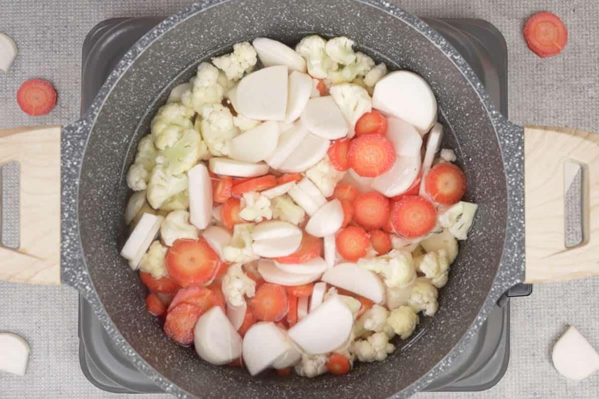 Verdure aggiunte alla pentola.