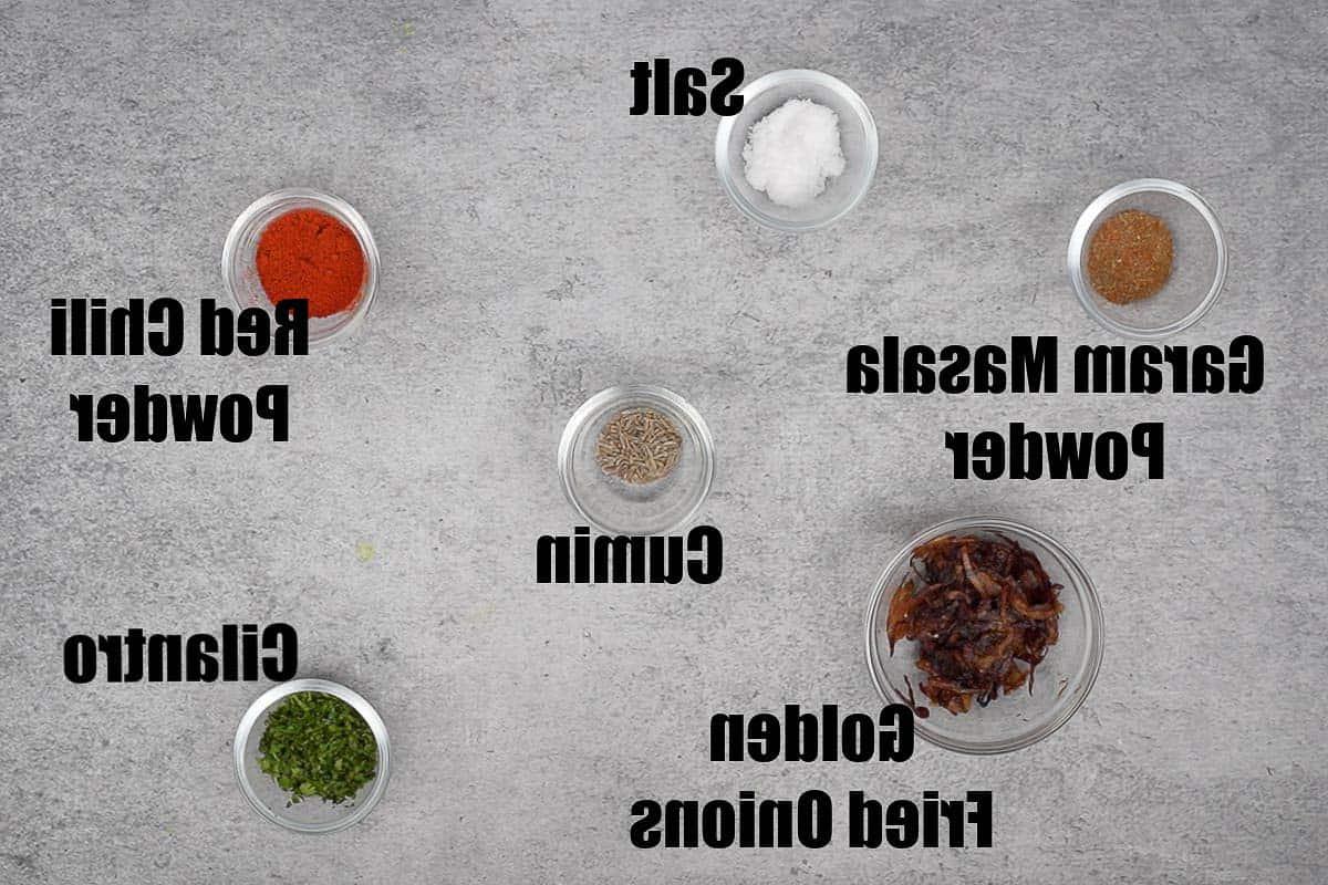 Ulteriori ingredienti per il curry indiano, incluse spezie e cipolle fritte croccanti.