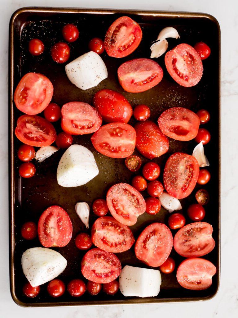 Zuppa Cremosa di Pomodori Arrostiti e Basilico 4 Pomodori Roma, pomodorini ciliegino, aglio e cipolla su una teglia cosparsi di olio d'oliva, sale e pepe