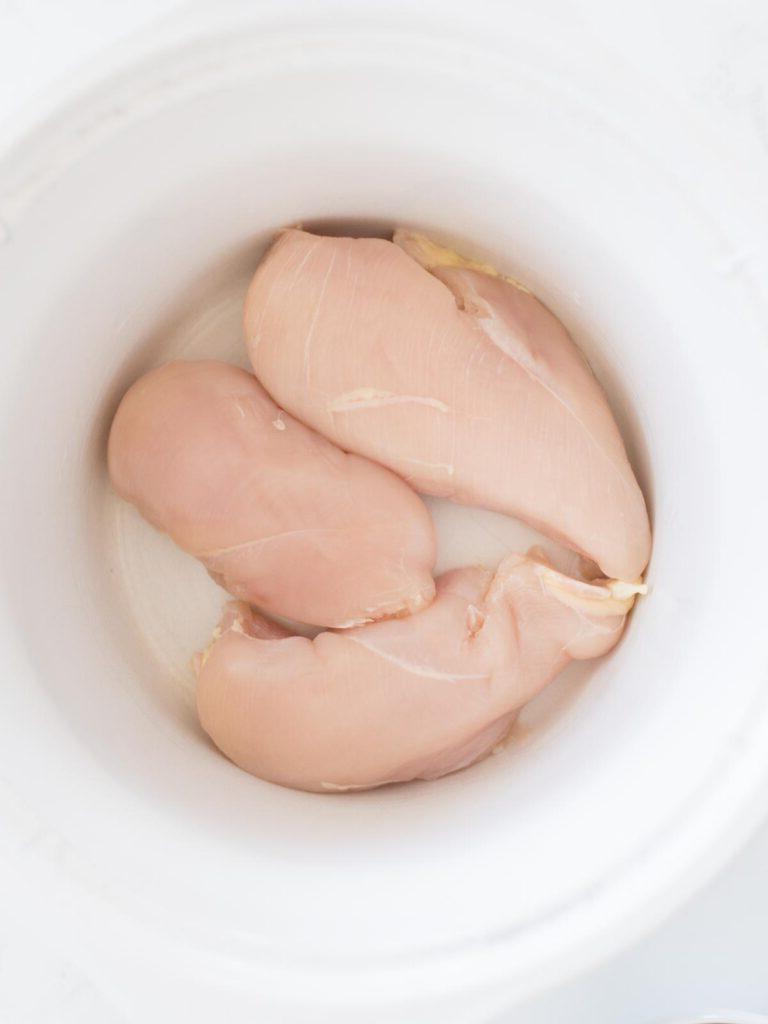 Pollo Messicano a Cottura Lenta 4 Petti di pollo crudi nella slow cooker pronti per essere conditi.