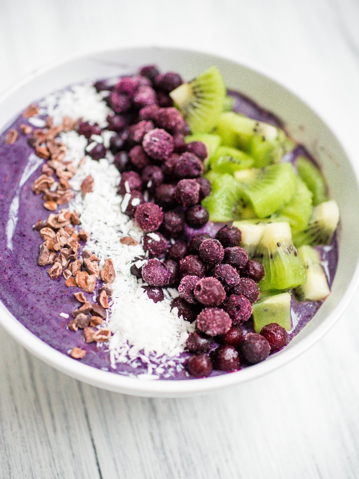 Smoothie Bowl Mirtillo e Banana 4 Smoothie bowl ai mirtilli e banane in una ciotola bianca con guarnizioni