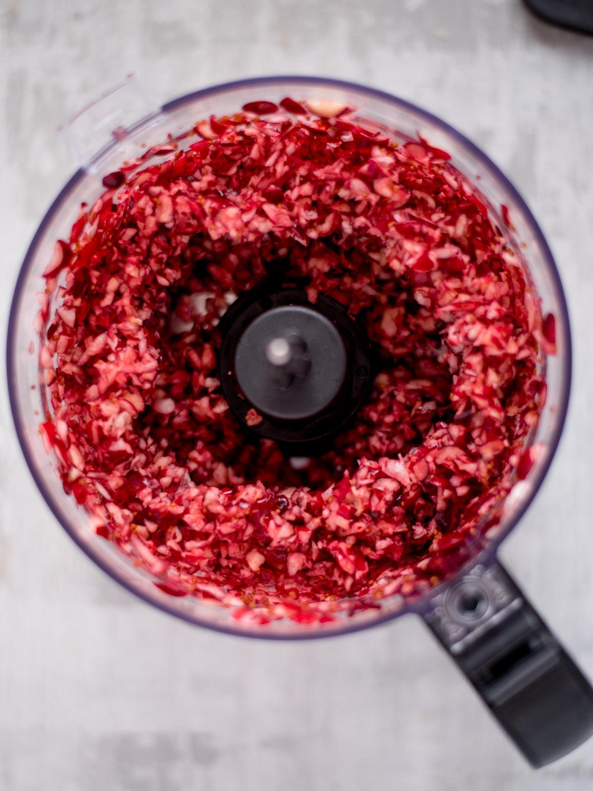 Salsa ai Mirtilli Rossi e Jalapeño 4 Food processer filled with diced cranberries.