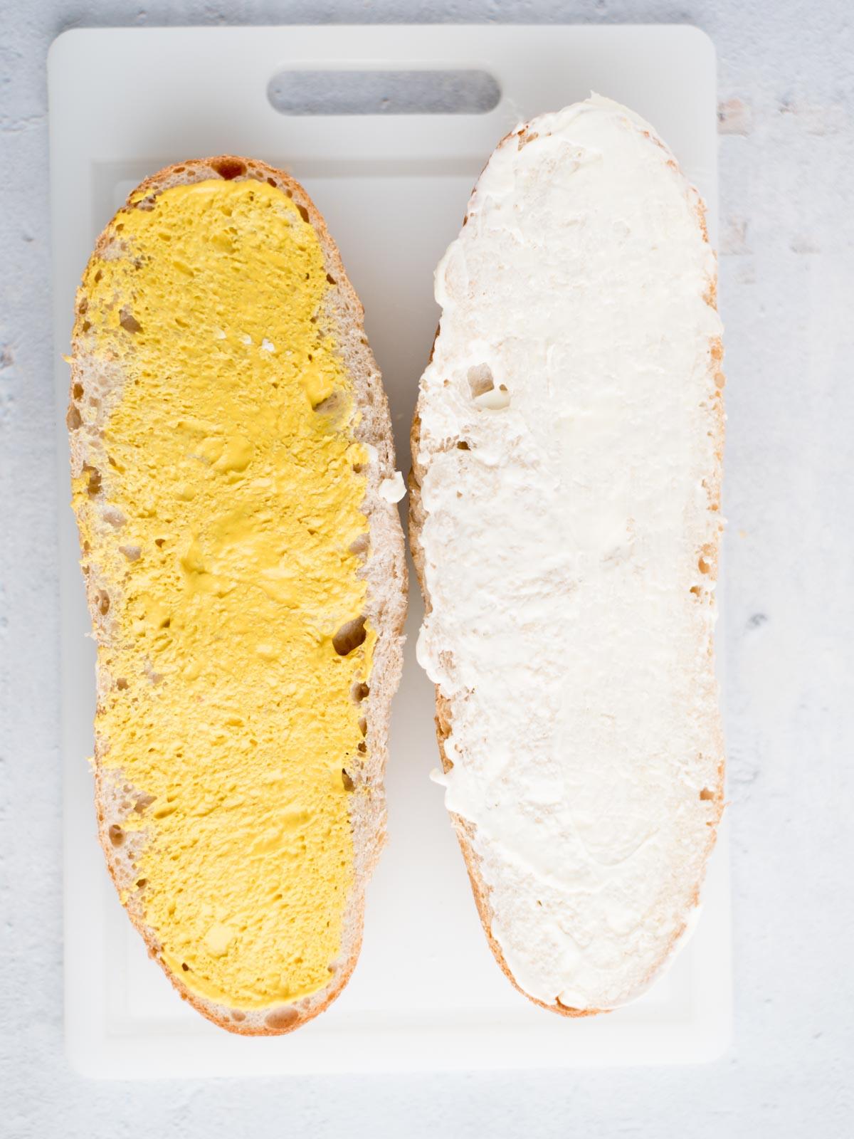 Ricetta Facile del Sandwich Cubano 4 Metà di una pagnotta di pane francese. Una è coperta di maionese e l'altra di senape.