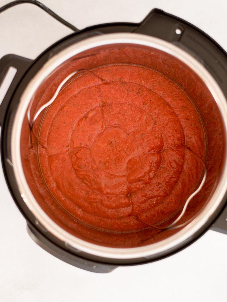 Polpette Congelate nell'Instant Pot 4 Salsa di pomodoro aggiunta a una pentola istantanea.