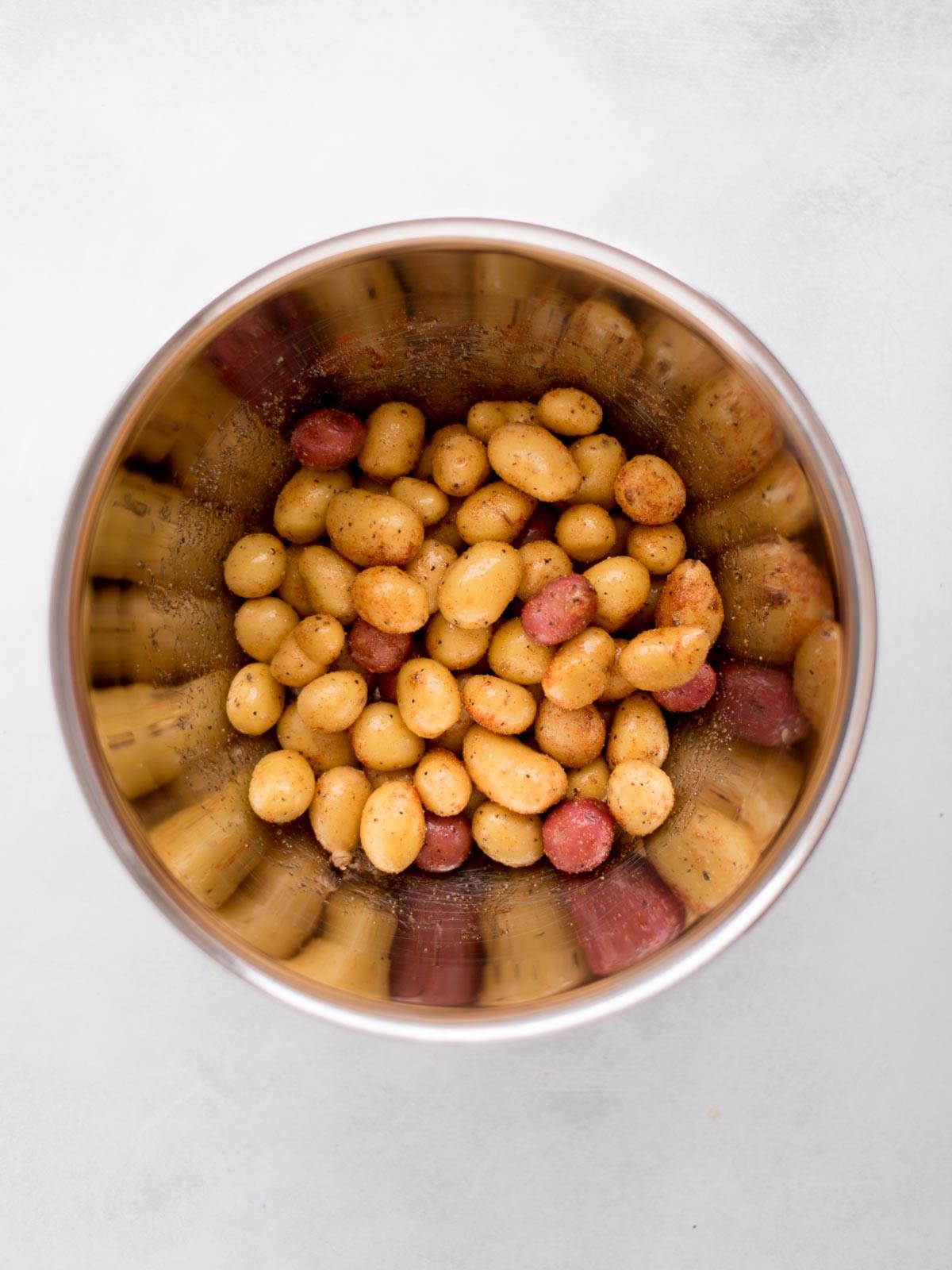 Patate Novelle in Friggitrice ad Aria 4 Patate novelle crude condite in una ciotola.