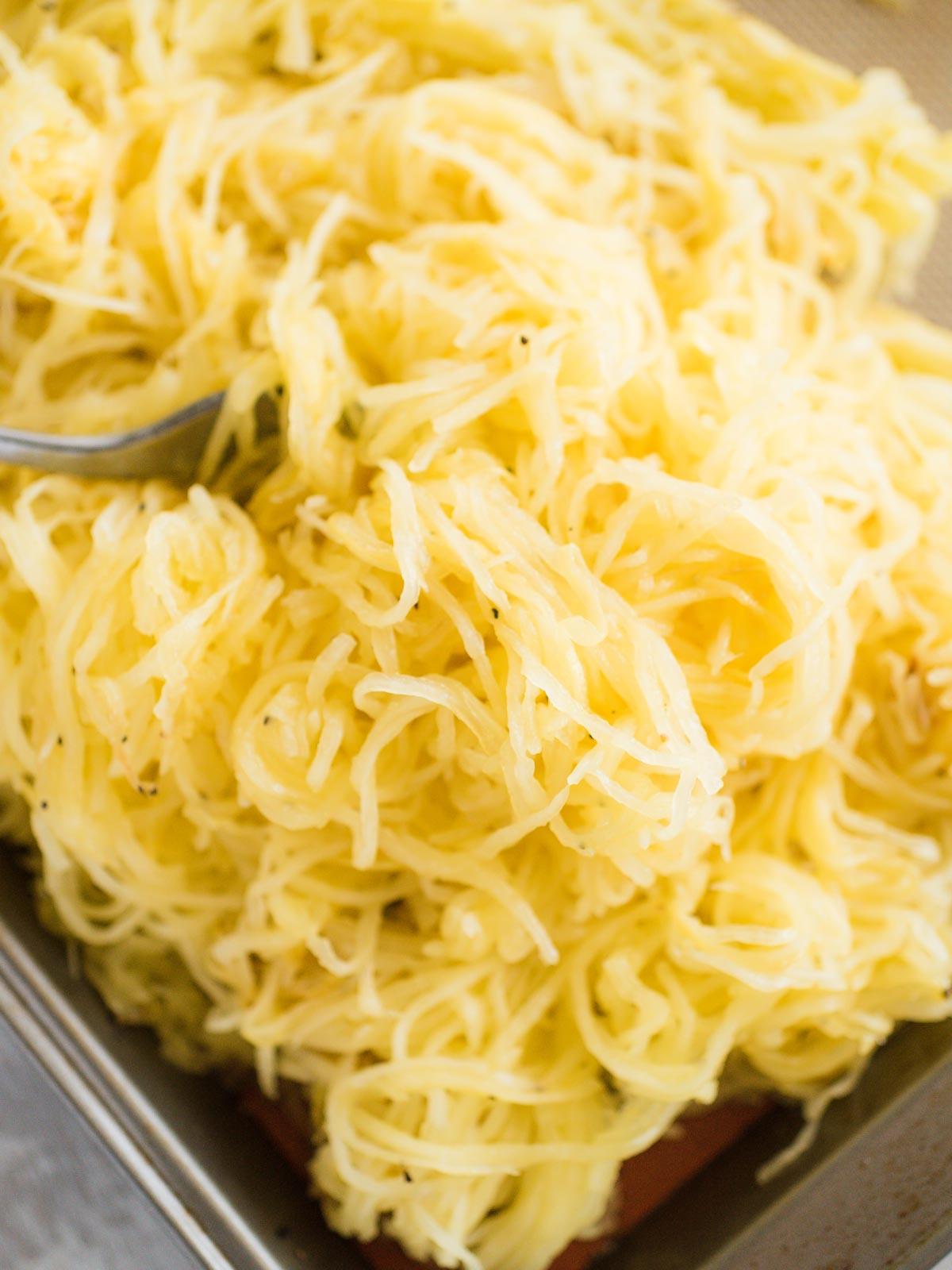 Come Arrostire la Zucca Spaghetti al Forno 4 Pila di zucca spaghetti arrostita su una teglia da forno