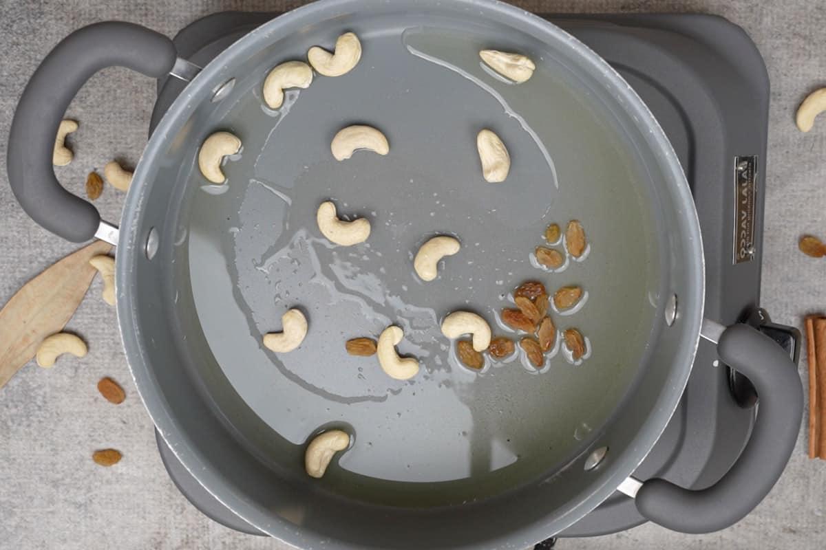 Uvetta e anacardi aggiunti alla padella.