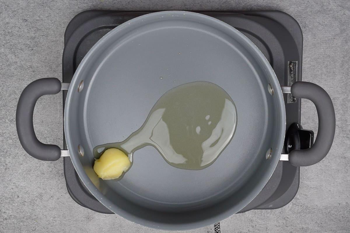 Olio e ghee si stanno scaldando in una pentola, pronti per la cottura.