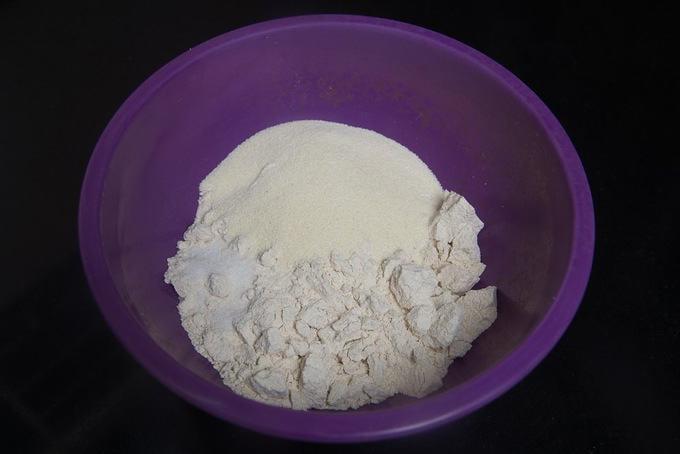 Farina integrale di grano e semola aggiunte in una ciotola.