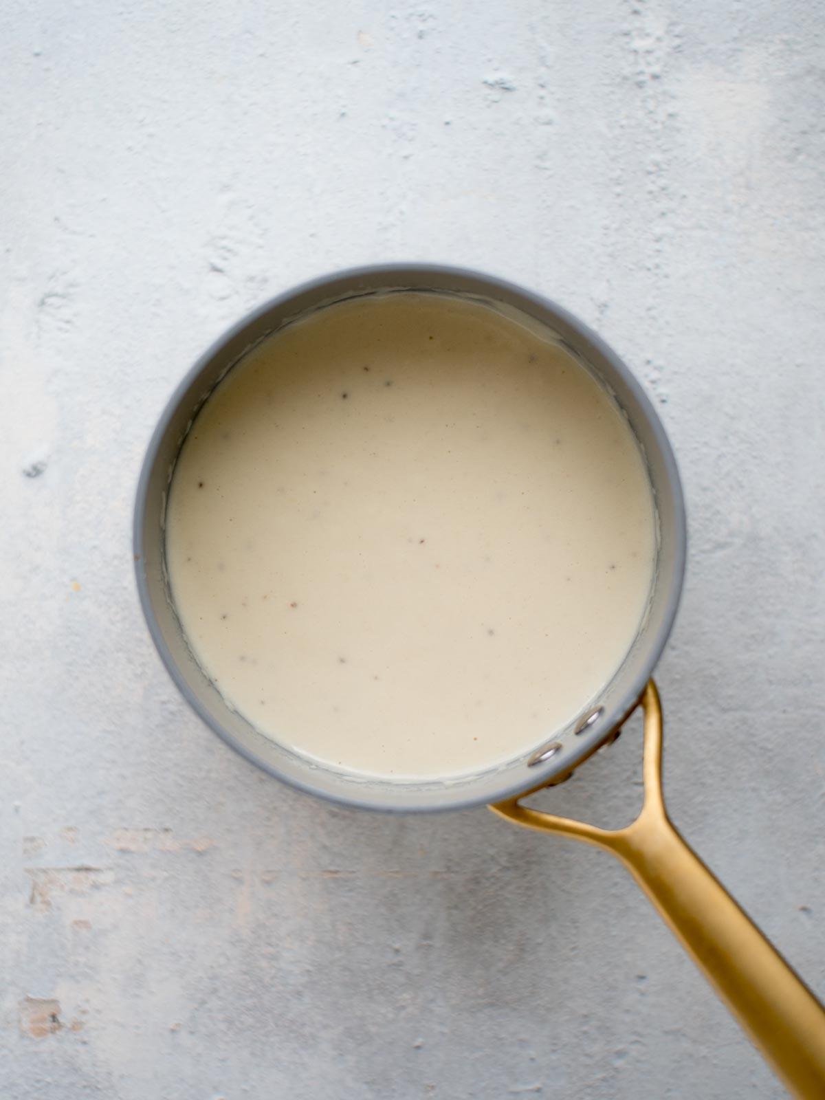 Salsa cremosa al Dijon e Parmigiano in una casseruola.