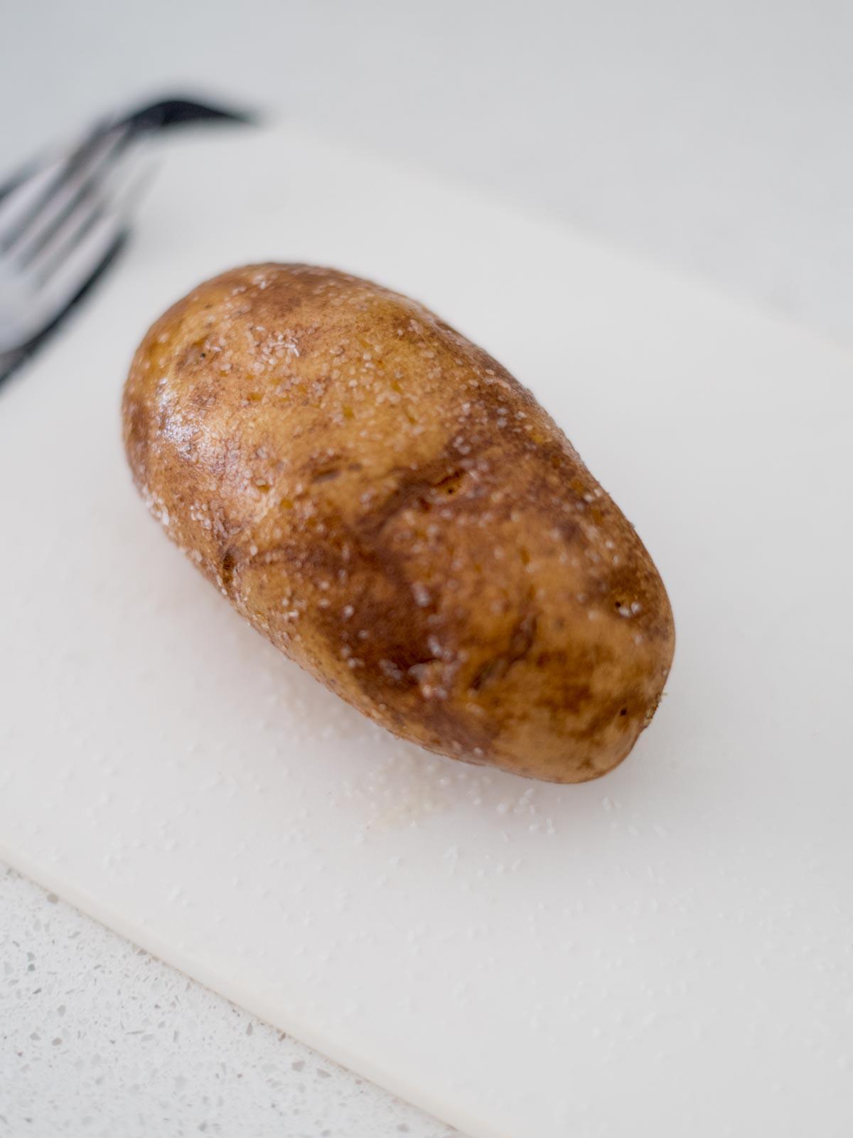 Patate Doppia Cottura in Friggitrice ad Aria 5 Una patata intera unta con olio e sale.