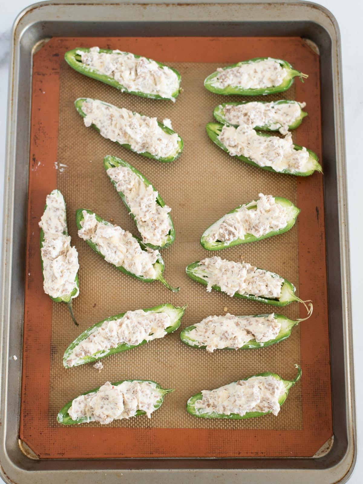 Facili Peperoncini Jalapeño Ripieni di Salsiccia al Forno 5 Peperoni Jalapeño Ripieni al Forno facili su una teglia da forno