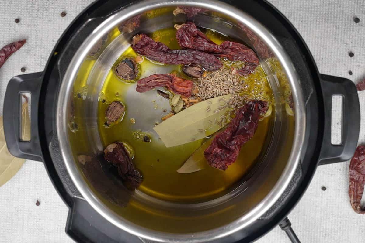 Rogan Josh di Montone 6 Spezie pestate aggiunte all'olio caldo nella Instant Pot.