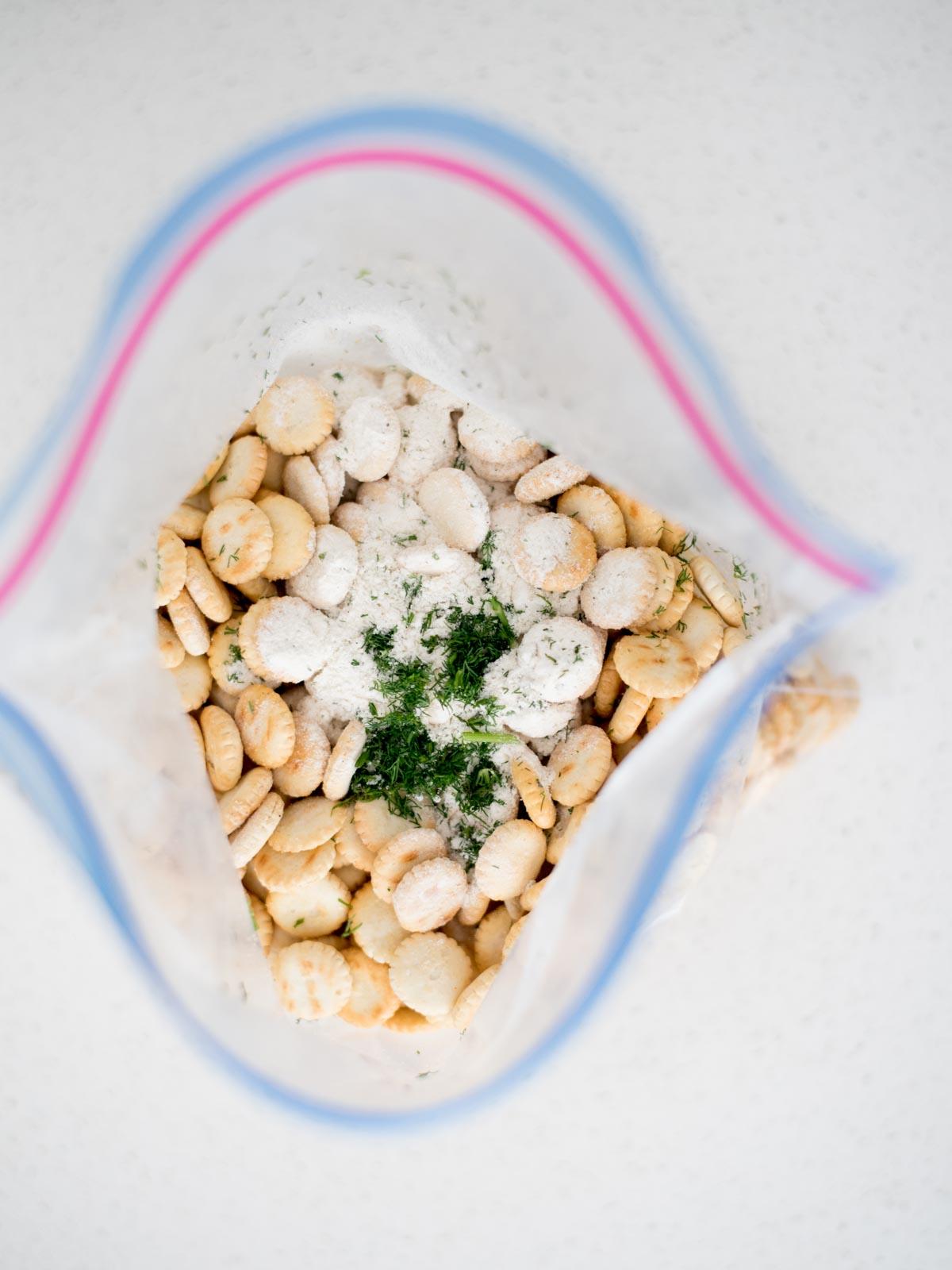 Sacchetto ziploc di cracker alle ostriche e condimenti aggiunti al sacchetto.