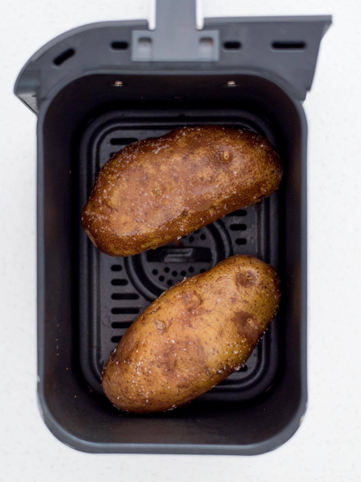 Patate Doppia Cottura in Friggitrice ad Aria 6 Due patate intere all'interno di un forno ad aria.