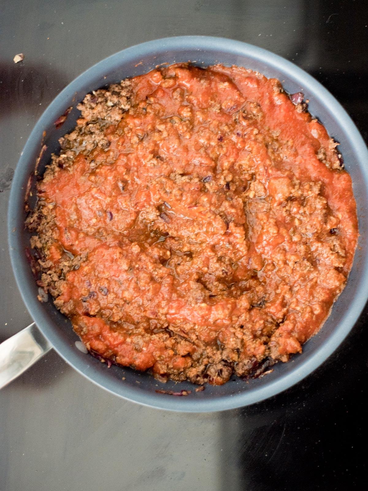 La Migliore Ricetta di Spaghetti al Forno (Facile) 6 Miscela di ragù di carne abbondante in una padella, pronta per condire gli spaghetti