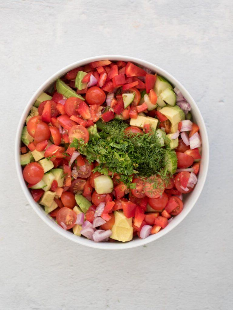 Insalata di Cetrioli, Pomodori, Cipolle e Avocado 6 Aneto e prezzemolo tritati aggiunti agli ingredienti tritati per l'insalata di cetrioli e pomodori.