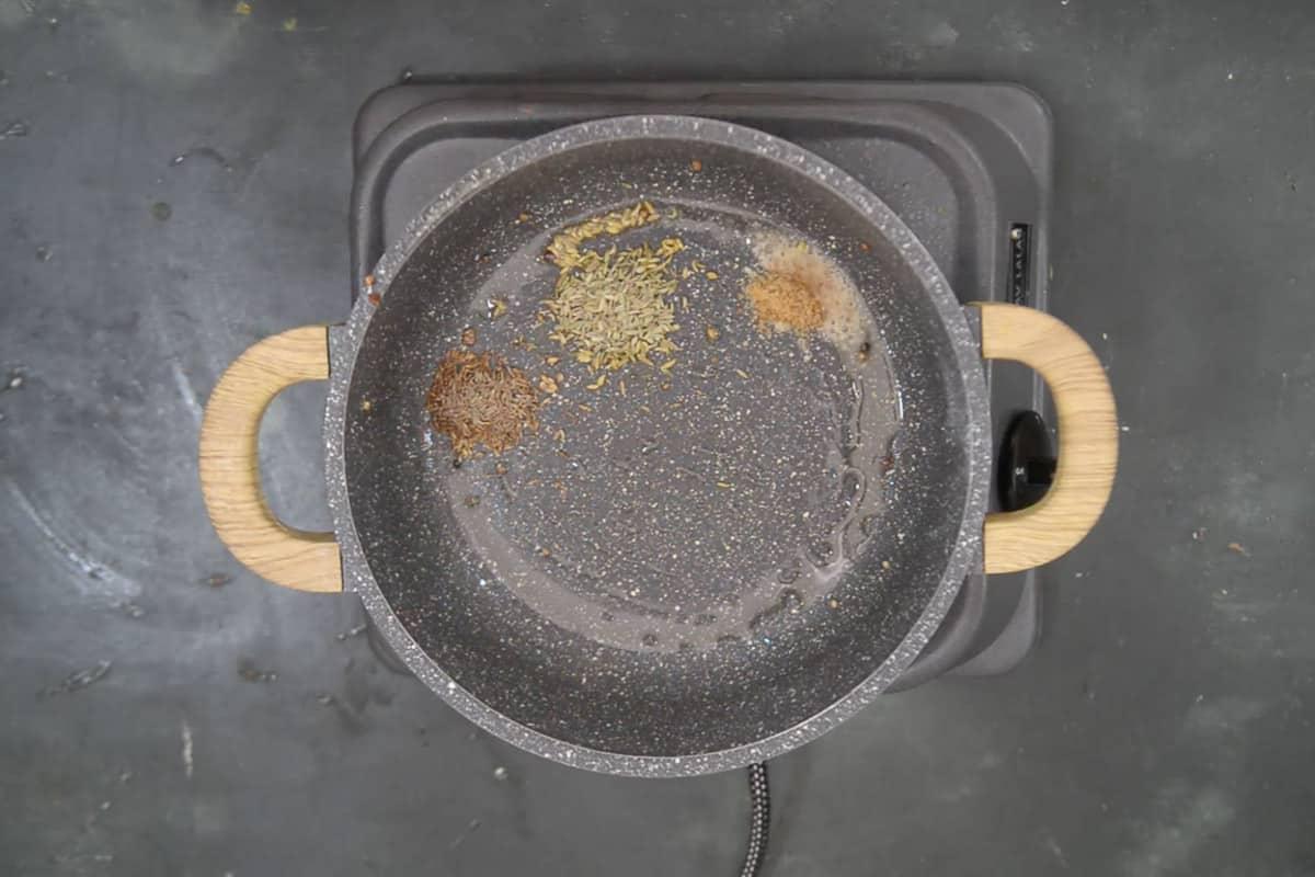 Gombo croccante alla farina di ceci 7 Semi di cumino, semi di finocchio e hing aggiunti nella padella.