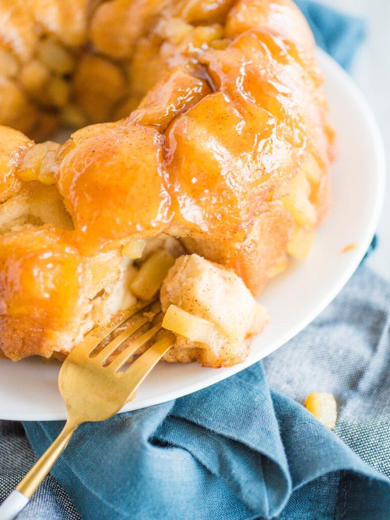Pane delle Scimmie alla Mela e Cannella con Biscotti Grands 7 apple cinnamon monkey bread on white plate with gold fork piercing a piece