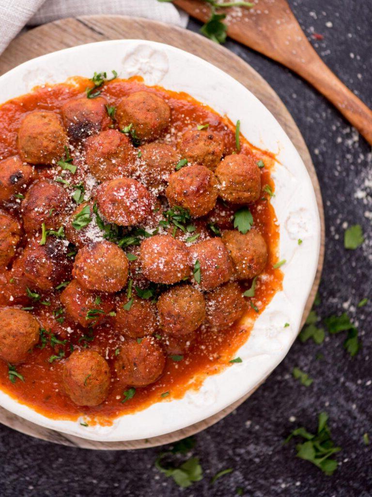 Polpette Congelate nell'Instant Pot 7 Vista dall'alto di una ciotola di polpette e salsa di pomodoro con un cucchiaio di legno accanto.