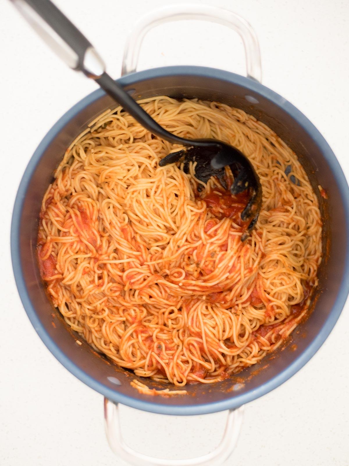 La Migliore Ricetta di Spaghetti al Forno (Facile) 7 Spaghetti cotti e salsa marinara mescolati insieme in una pentola, pronti per essere stratificati