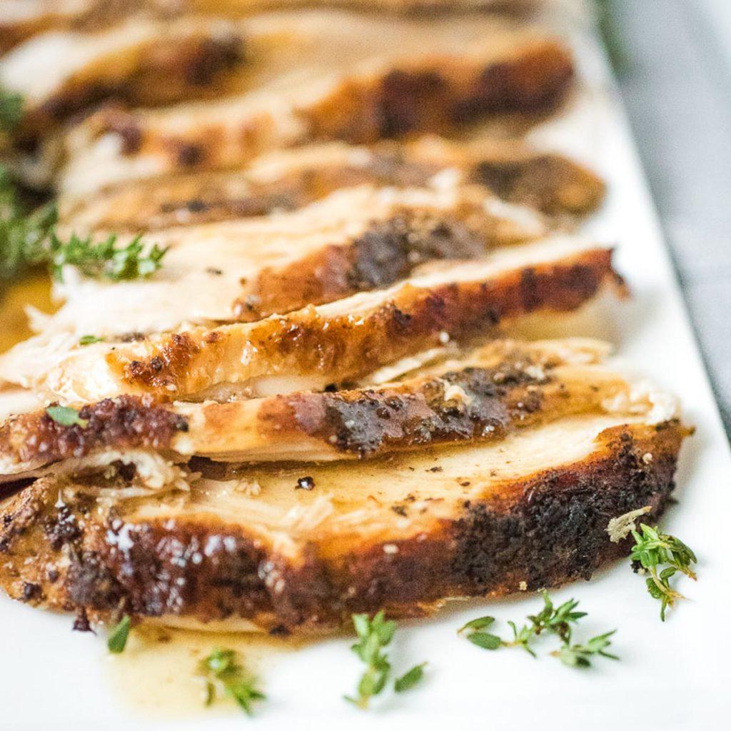 Ricette Instant Pot per il Ringraziamento 6 Fette di petto di tacchino su un piatto con salsa gravy