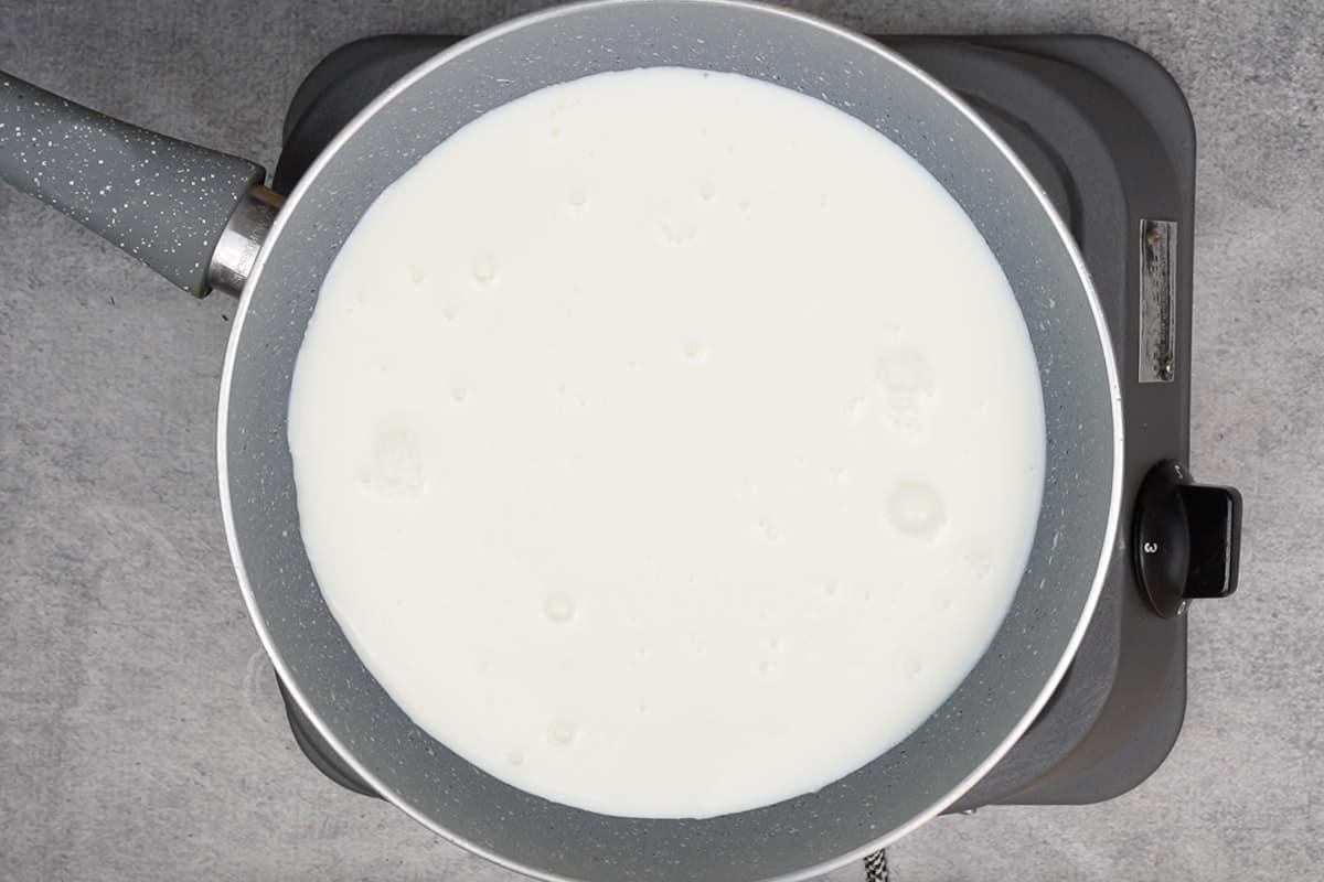 Dolce di pane 7 Latte che si scalda in una casseruola.