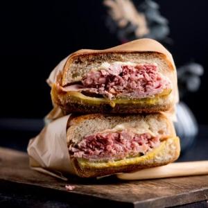 Ricetta Facile del Sandwich Cubano 8 Panini cubani impilati su un tagliere di legno