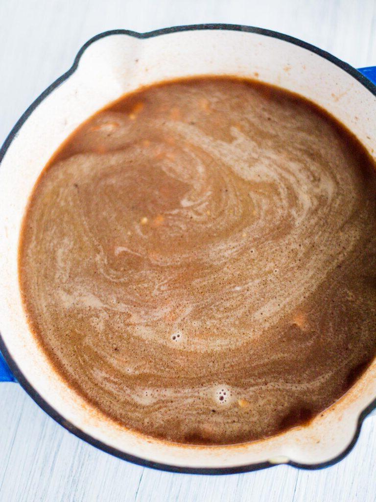 Brodo vegetale versato in padella sull'orzo